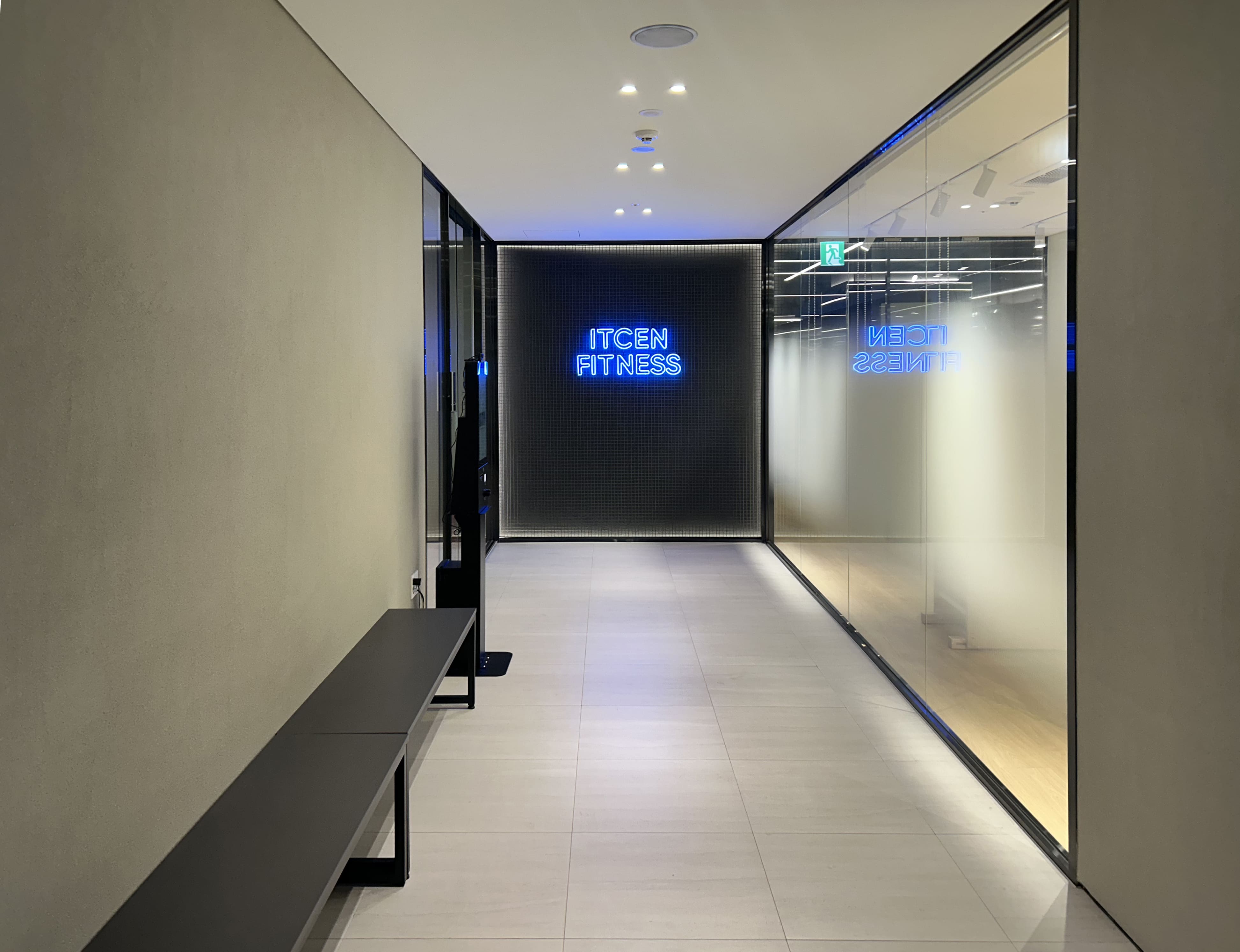 아이티센 ITCEN FITNESS 피트니스 센터 입구 복도 에이맷 스튜디오 인테리어 시공 사례, 블루 네온 브랜드 사이니지와 유리 파티션 엔트런스